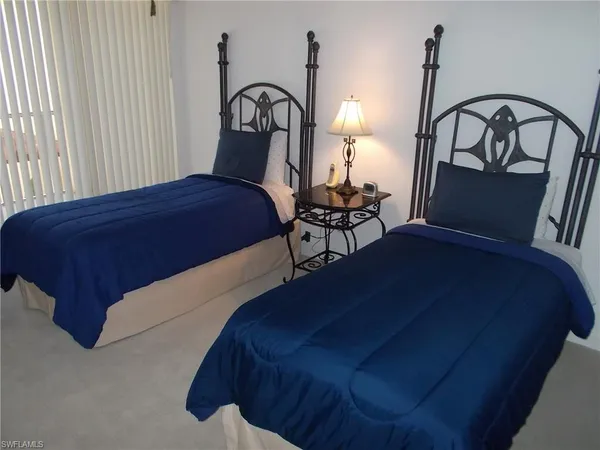 a bedroom with a bed a lamp and the window
