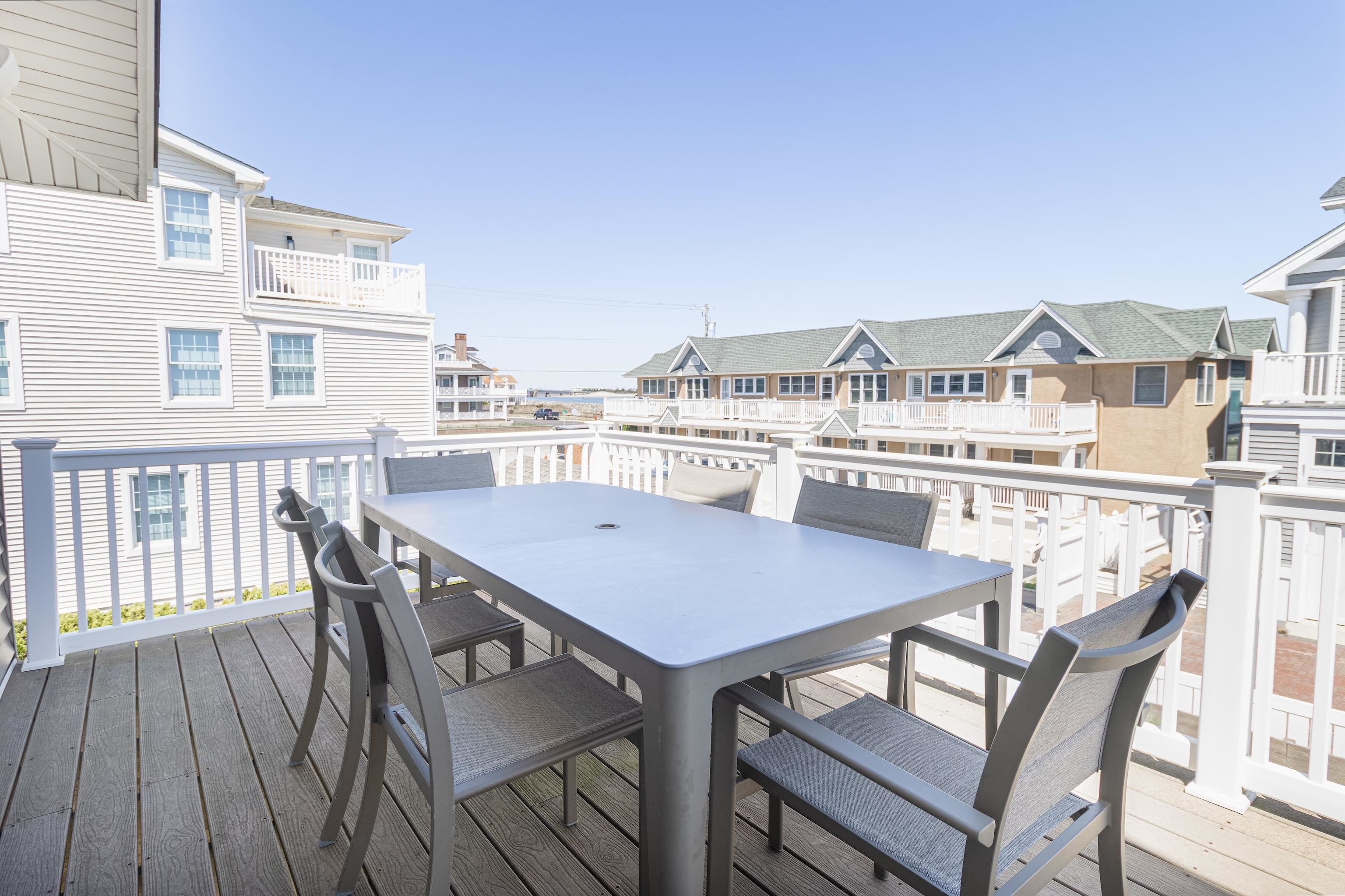 181 7th Street Avalon, NJ 08202 - Photo 17 of 29 a terrace of a house with wooden table and chairs