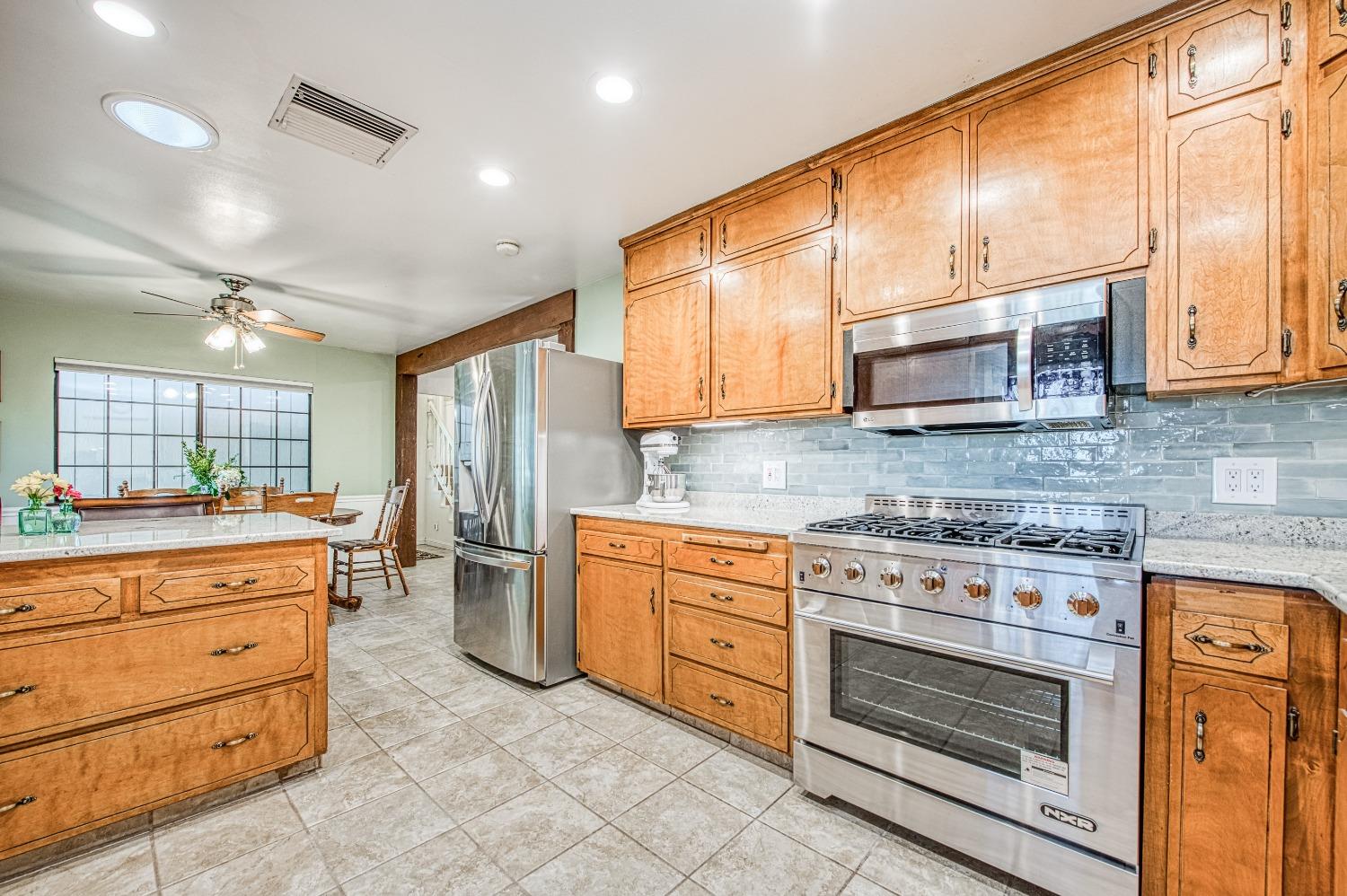 30128 Auberry Road Prather, CA 93651 - Photo 11 of 99 a kitchen with stainless steel appliances granite countertop a stove and cabinets