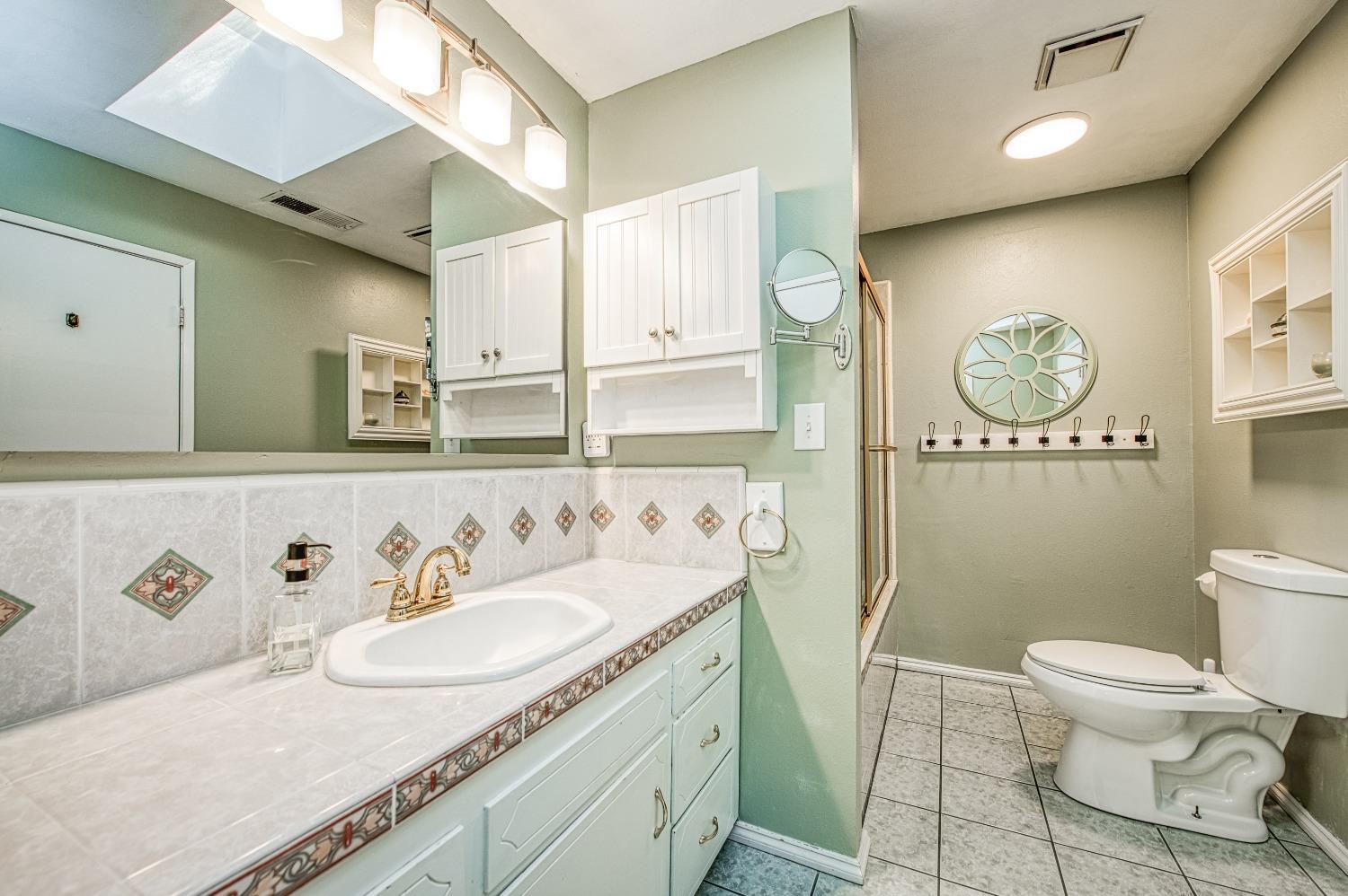30128 Auberry Road Prather, CA 93651 - Photo 13 of 99 a spacious bathroom with a granite countertop sink a toilet and a mirror