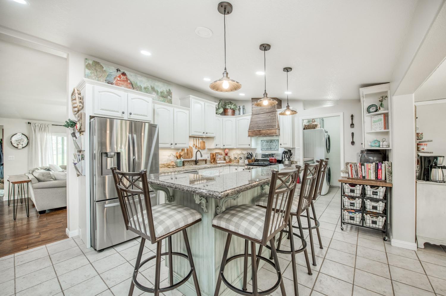 30128 Auberry Road Prather, CA 93651 - Photo 49 of 99 a kitchen with stainless steel appliances kitchen island granite countertop a table chairs and a view of living room