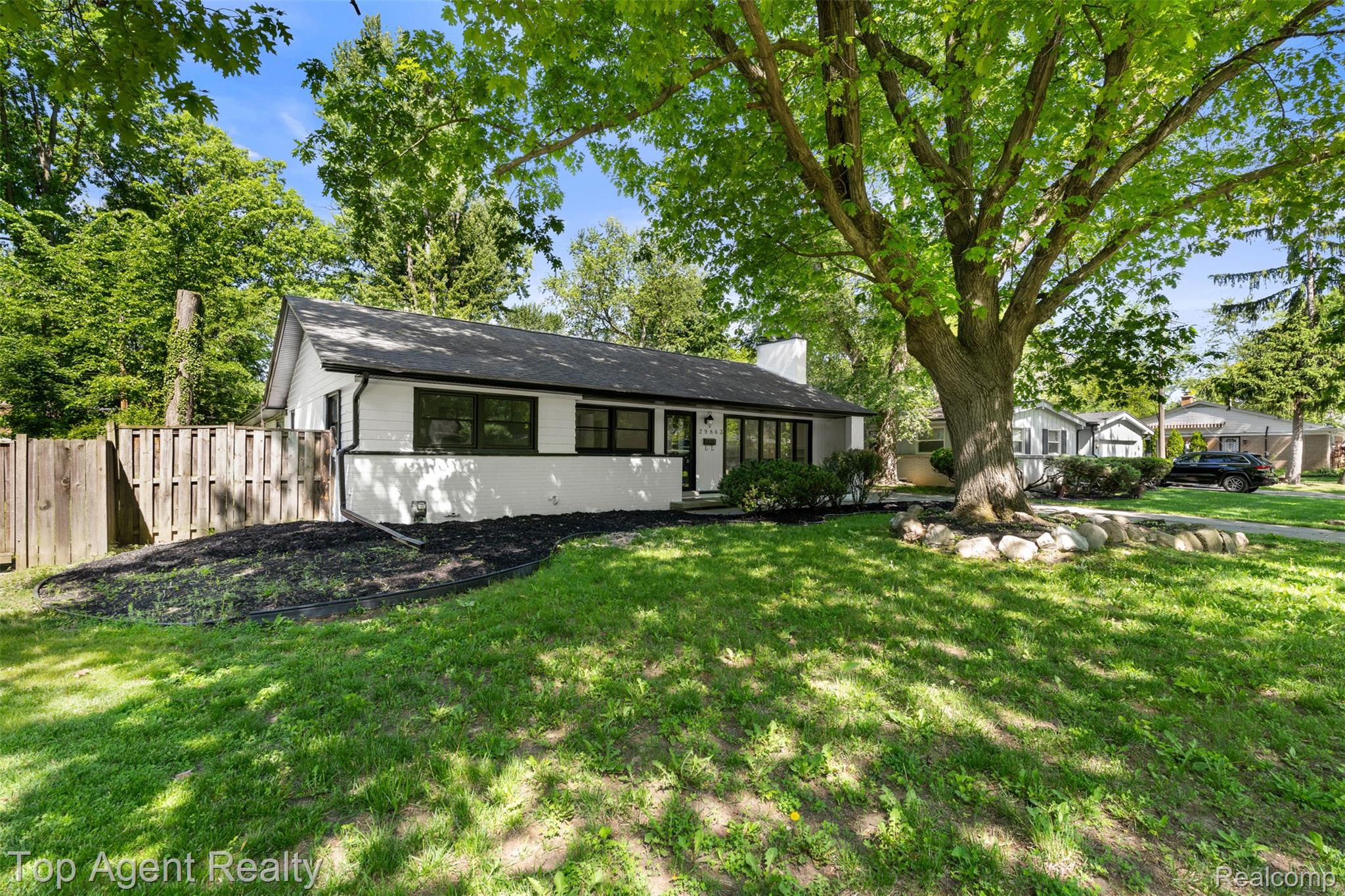 29863 Fall River Road Southfield, MI 48076 - Photo 2 of 50 White exterior with black trim, a dark shingle roof, and a prominent chimney
