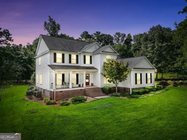 a front view of a house with a garden and yard