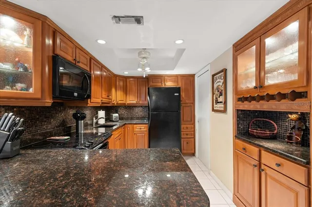 a kitchen with stainless steel appliances granite countertop a refrigerator a stove and a sink with granite countertops