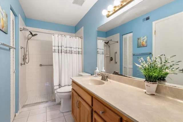 a bathroom with a granite countertop sink a toilet and shower