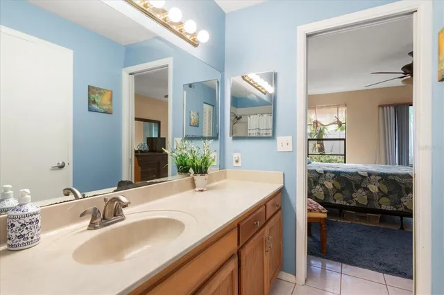 a en suite bathroom with a granite countertop sink and a mirror