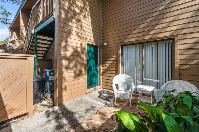 a patio with table and chairs and potted plants