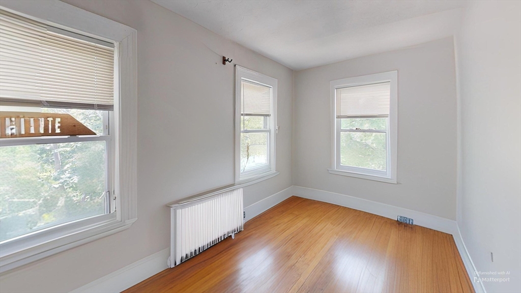 1789 Commonwealth Avenue, Unit 2 Boston, MA 02135 - Photo 14 of 16 an empty room with wooden floor and windows