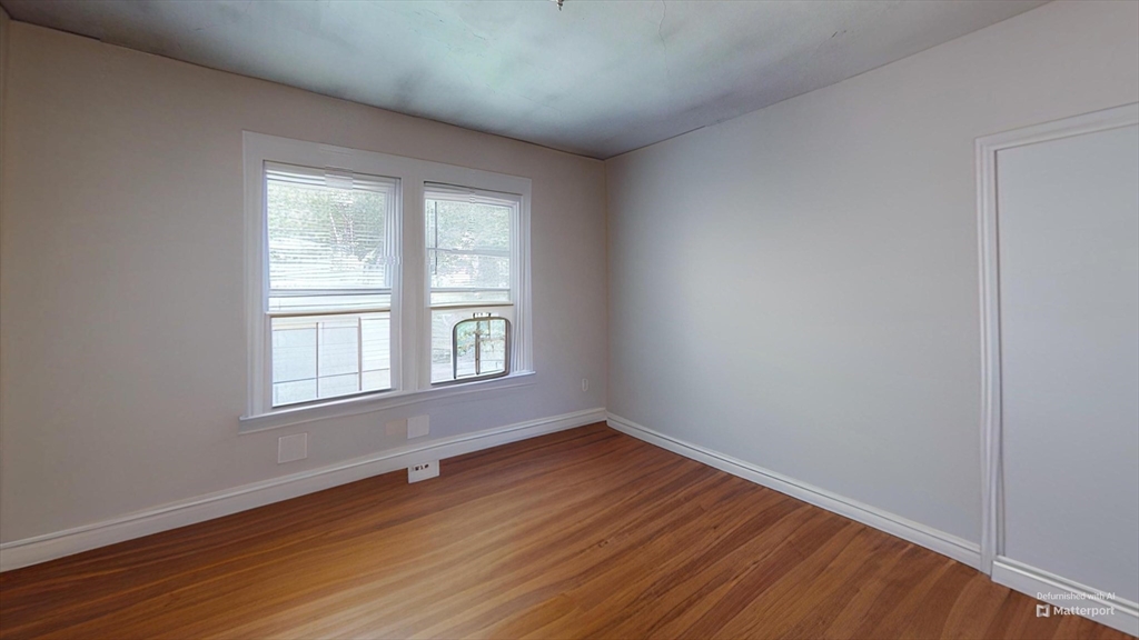 1789 Commonwealth Avenue, Unit 2 Boston, MA 02135 - Photo 6 of 16 an empty room with wooden floor and windows