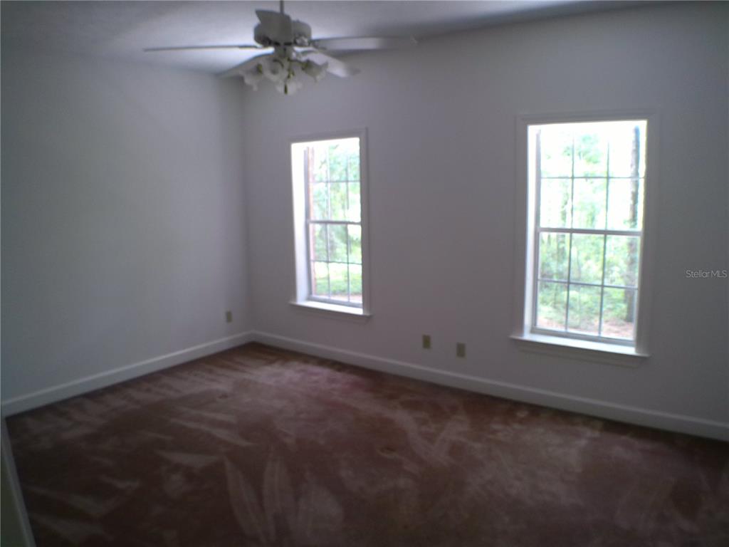 415 Southeast 123rd Street Road Ocala, FL 34480 - Photo 28 of 50 an empty room with windows and fan