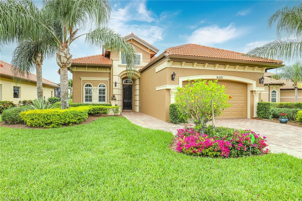 a front view of a house with a big yard and potted plants
