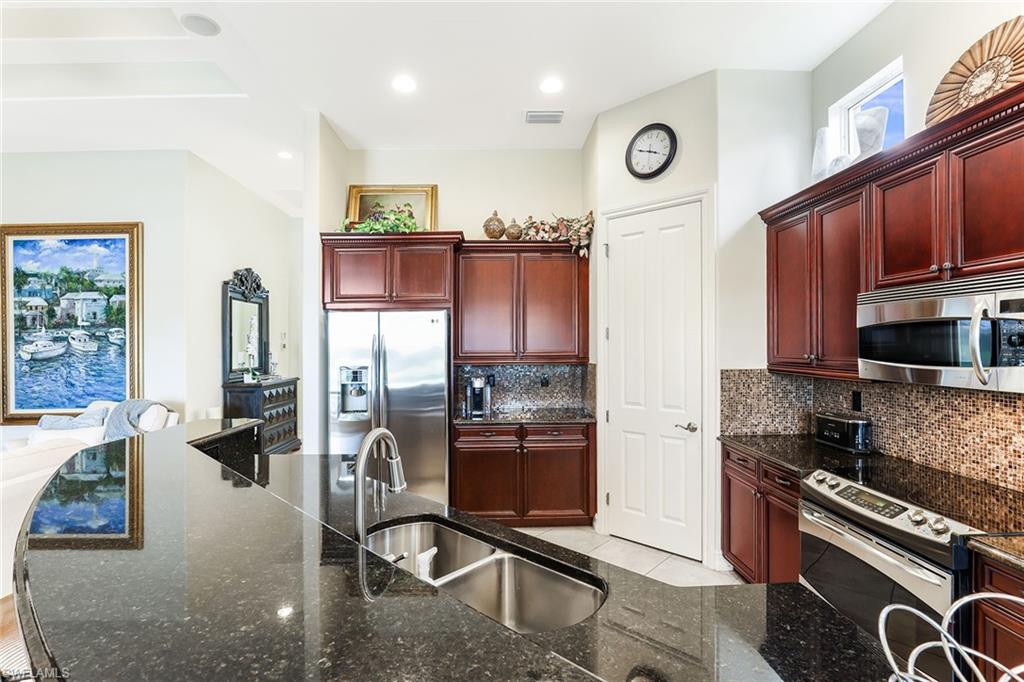 6581 Caldecott Drive Naples, FL 34113 - Photo 17 of 34 a kitchen with stainless steel appliances granite countertop a refrigerator stove and sink