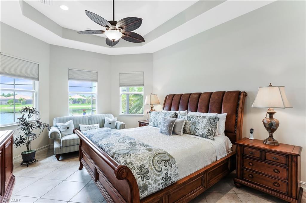6581 Caldecott Drive Naples, FL 34113 - Photo 20 of 34 a bedroom with a large bed and a chandelier fan