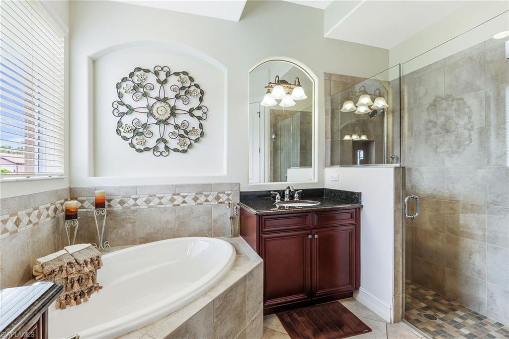 6581 Caldecott Drive Naples, FL 34113 - Photo 21 of 34 a bathroom with a tub a sink and mirror