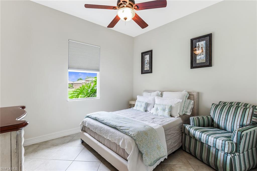 6581 Caldecott Drive Naples, FL 34113 - Photo 25 of 34 a bedroom with a bed and a chandelier