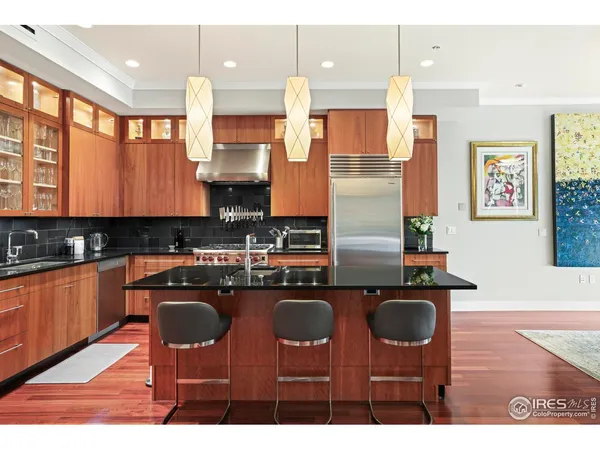 a kitchen with kitchen island a counter top space a sink stainless steel appliances and cabinets