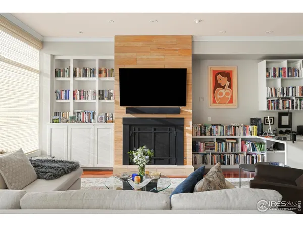 a living room with furniture a flat screen tv and a floor to ceiling window