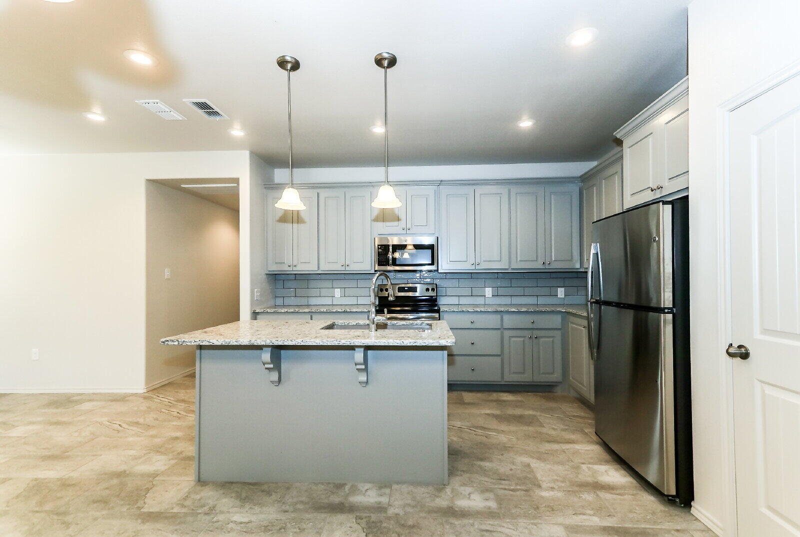 6903 67th Street, Unit A Lubbock, TX 79424 - Photo 11 of 32 a kitchen with a refrigerator a sink and cabinets