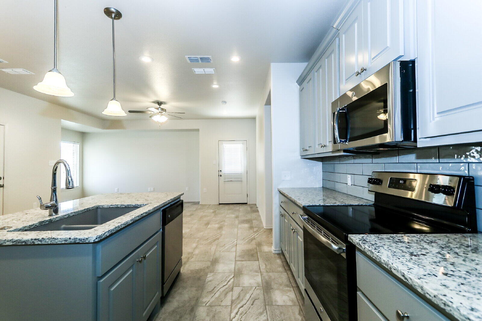 6903 67th Street, Unit A Lubbock, TX 79424 - Photo 13 of 32 a kitchen with stainless steel appliances granite countertop a sink a stove and a microwave