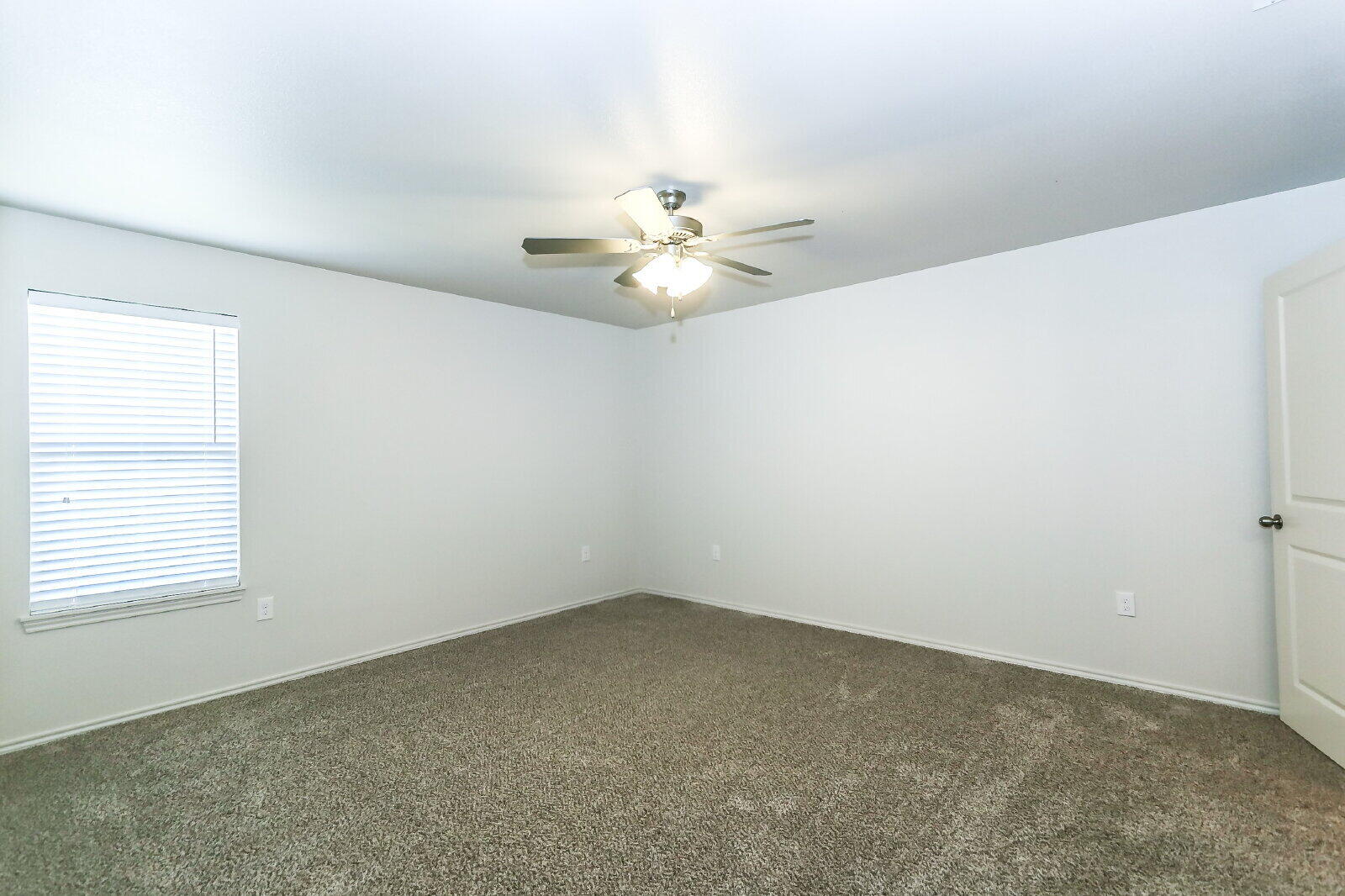 6903 67th Street, Unit A Lubbock, TX 79424 - Photo 18 of 32 an empty room with windows and chandelier fan