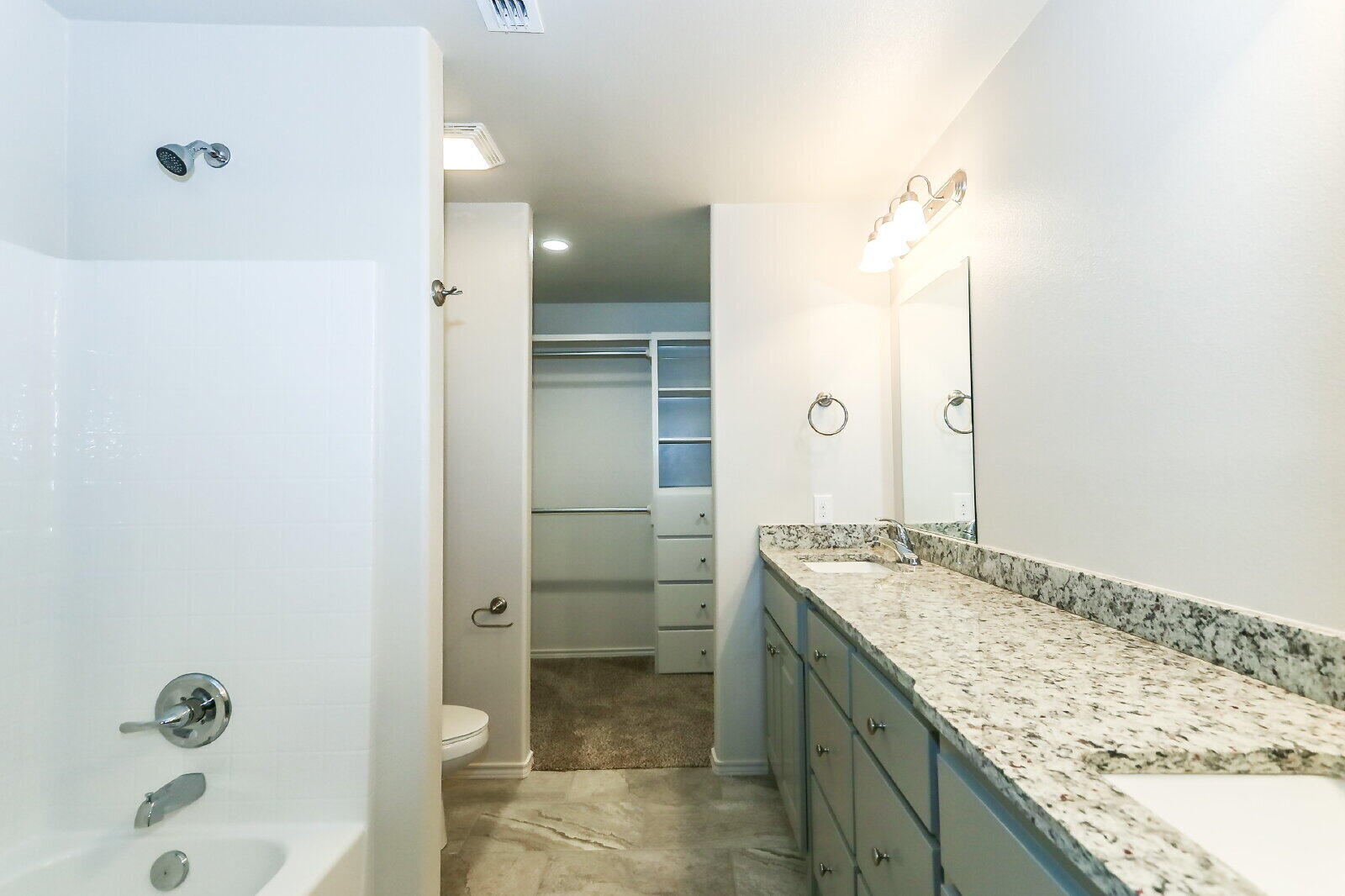 6903 67th Street, Unit A Lubbock, TX 79424 - Photo 20 of 32 a bathroom with a granite countertop sink mirror and shower