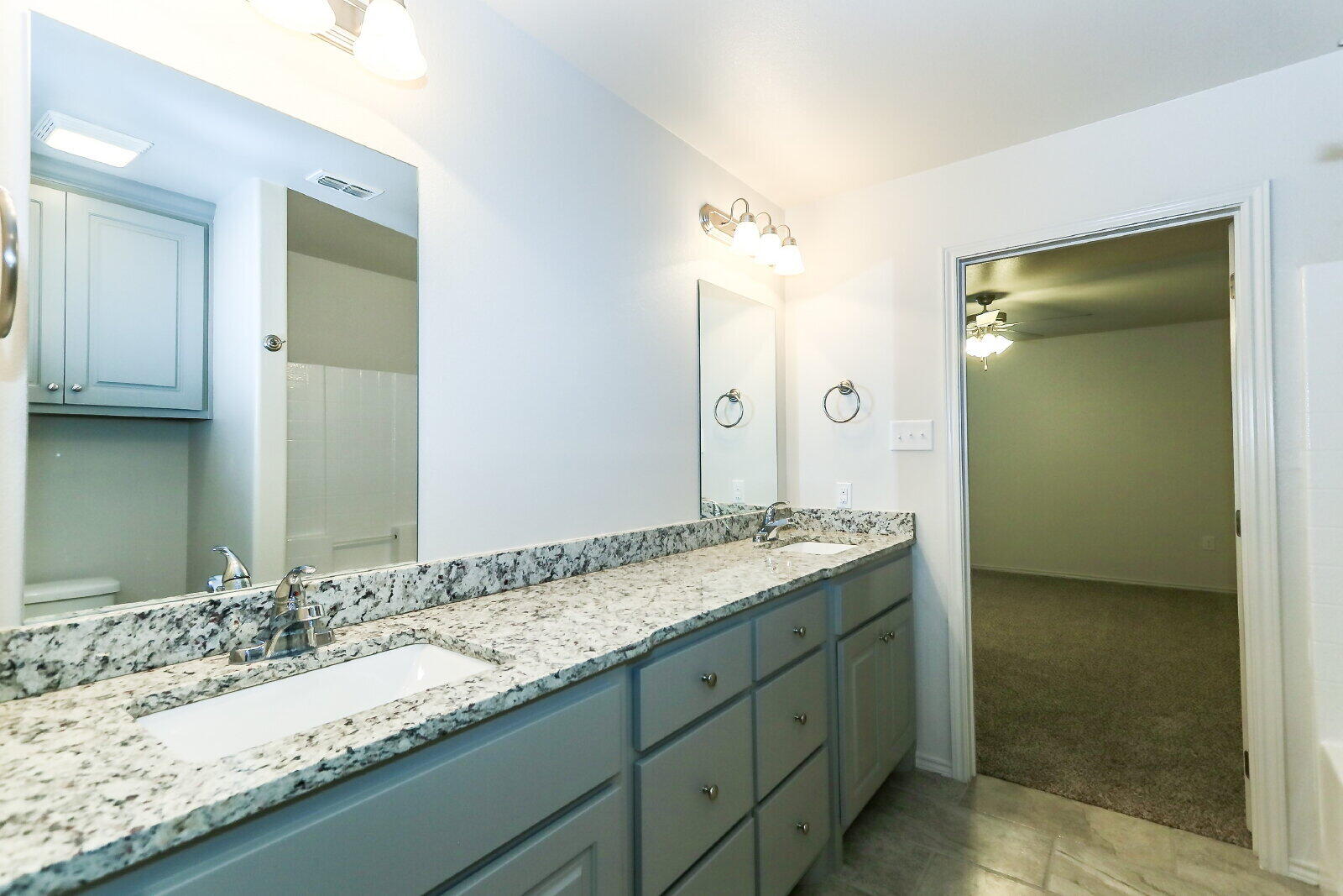 6903 67th Street, Unit A Lubbock, TX 79424 - Photo 22 of 32 a bathroom with a granite countertop sink and a mirror