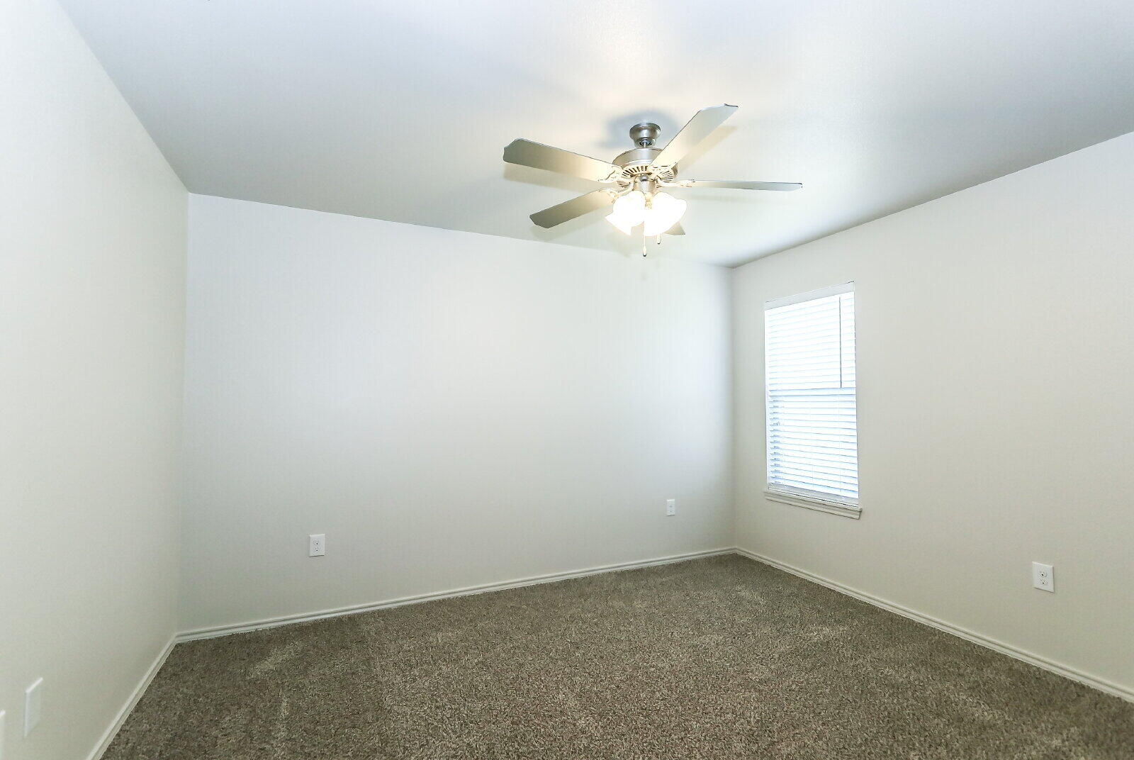 6903 67th Street, Unit A Lubbock, TX 79424 - Photo 26 of 32 an empty room with windows and fan