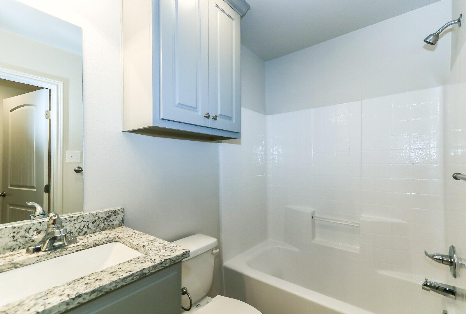 6903 67th Street, Unit A Lubbock, TX 79424 - Photo 29 of 32 a bathroom with a granite countertop sink a toilet and bathtub