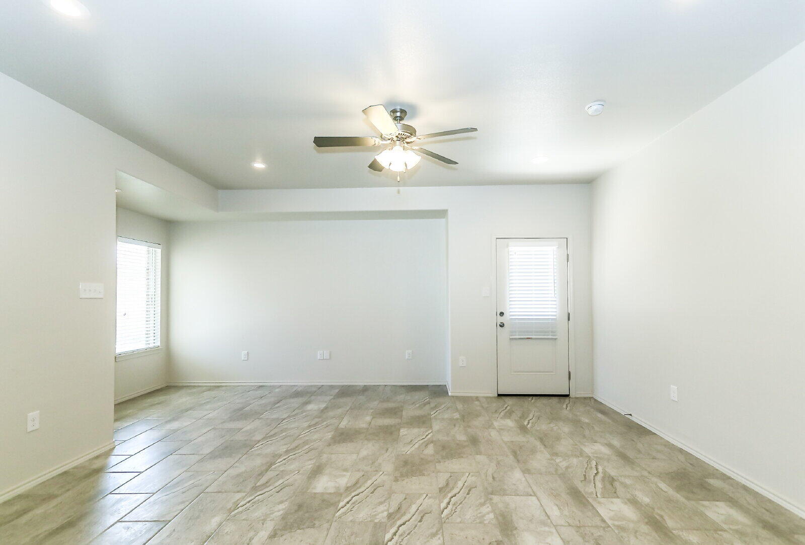 6903 67th Street, Unit A Lubbock, TX 79424 - Photo 5 of 32 an empty room with chandelier fan and windows
