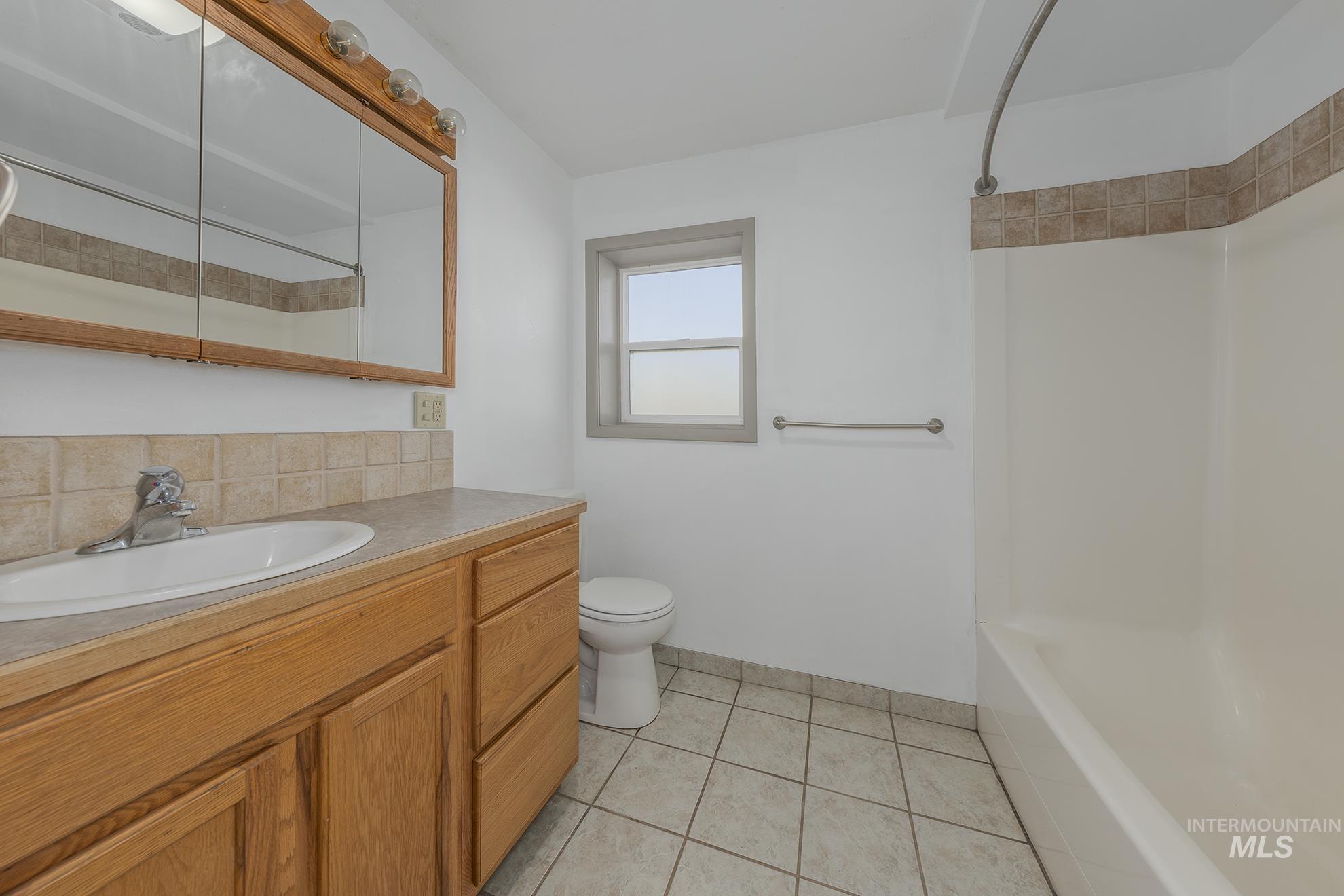 28552 Market Road Caldwell, ID 83607 - Photo 19 of 50 Full bath with vanity, shower / tub combination, and light tile patterned flooring