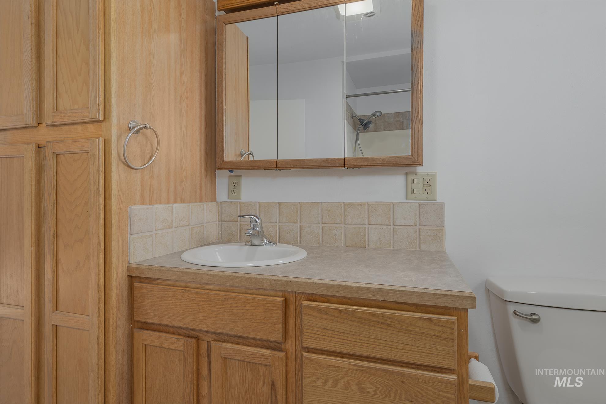 28552 Market Road Caldwell, ID 83607 - Photo 20 of 50 Bathroom with vanity, a shower with shower door, and decorative backsplash