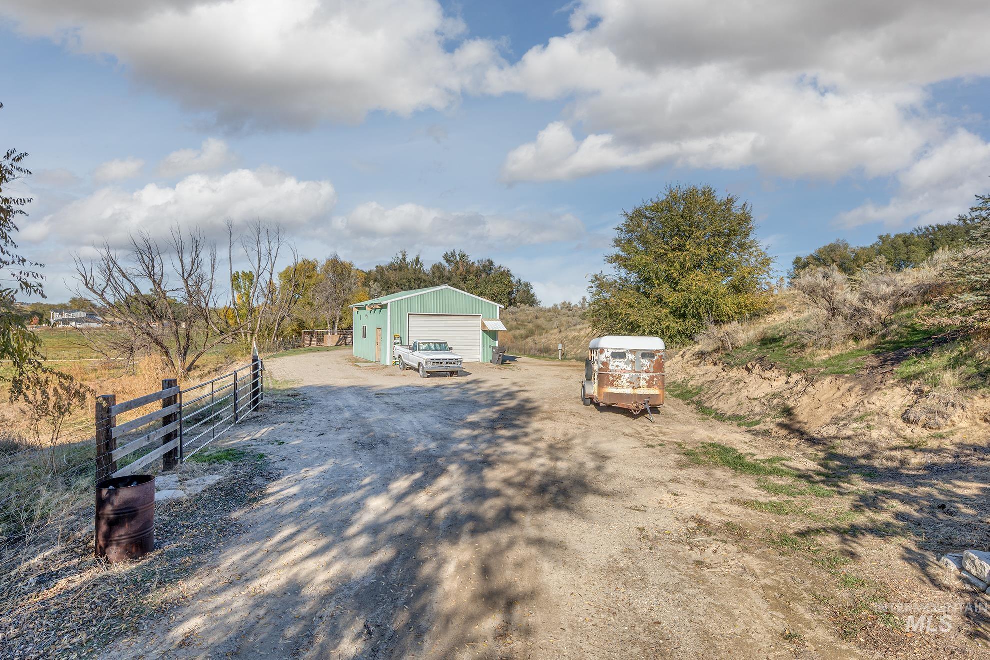 28552 Market Road Caldwell, ID 83607 - Photo 35 of 50 View of front of property featuring an outdoor structure, a detached garage, and a view of countryside