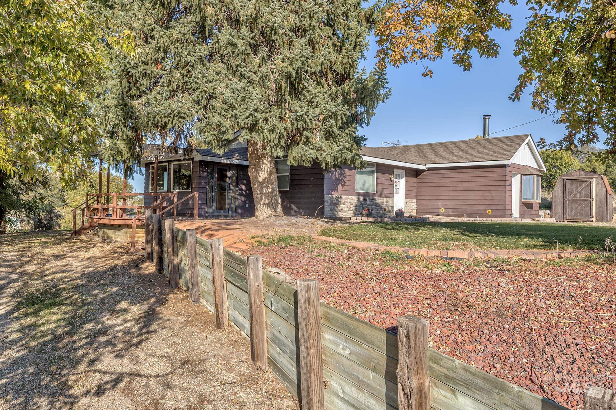 28552 Market Road Caldwell, ID 83607 - Photo 46 of 50 View of front of house with a wooden deck, a storage shed, and a shingled roof