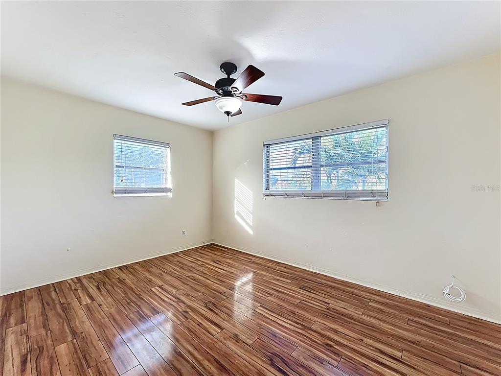 12295 Ridge Road Largo, FL 33778 - Photo 14 of 31 a view of empty room with wooden floor and fan