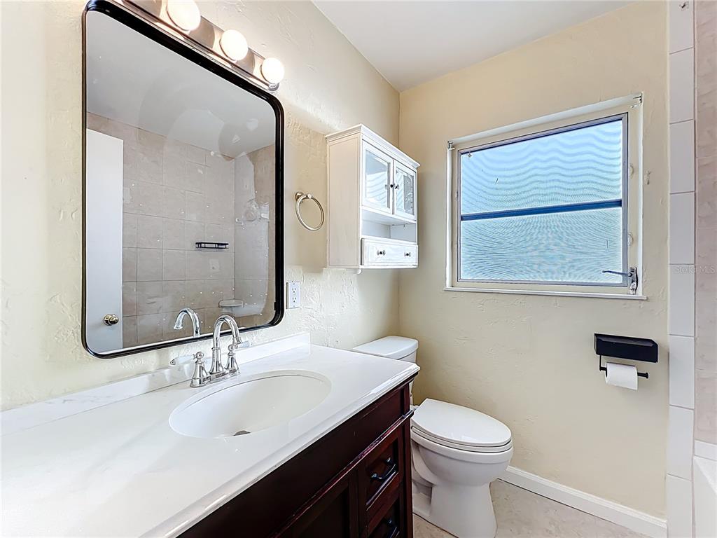 12295 Ridge Road Largo, FL 33778 - Photo 16 of 31 a bathroom with a sink vanity mirror and toilet
