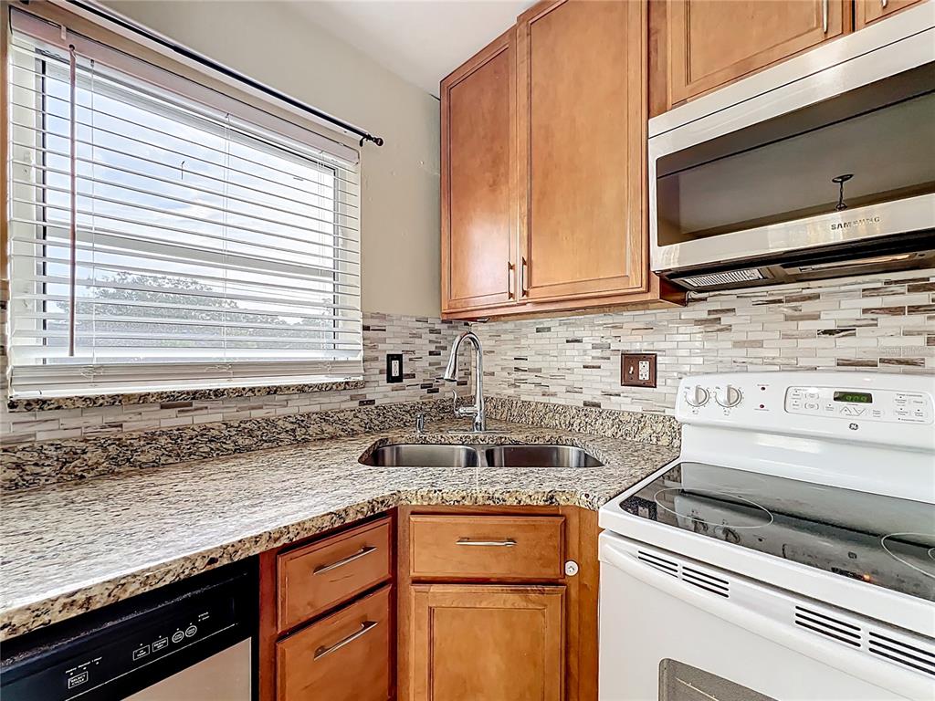 12295 Ridge Road Largo, FL 33778 - Photo 8 of 31 a kitchen with granite countertop a sink stainless steel appliances and cabinets