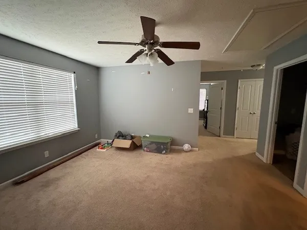 a view of a room with a window and a ceiling fan