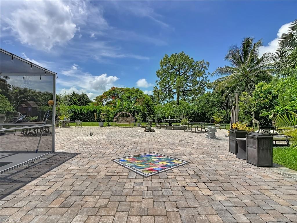 2280 Capri Court Naples, FL 34105 - Photo 34 of 49 a backyard of a house with yard and outdoor seating