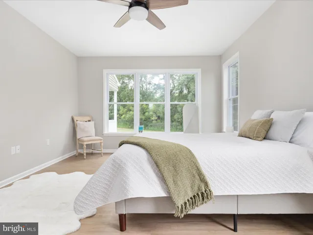 a bed sitting in a bedroom next to a window with a lamp