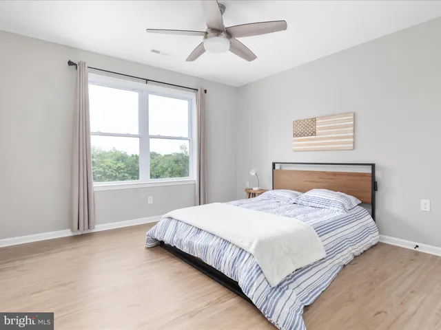 a bedroom with a bed and a chandelier fan