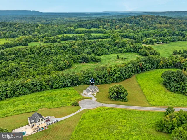 an aerial view of a house with swimming pool and big yard
