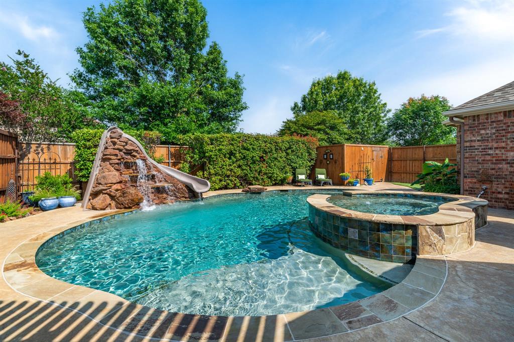 a view of a backyard with table and chairs potted plants and large tree