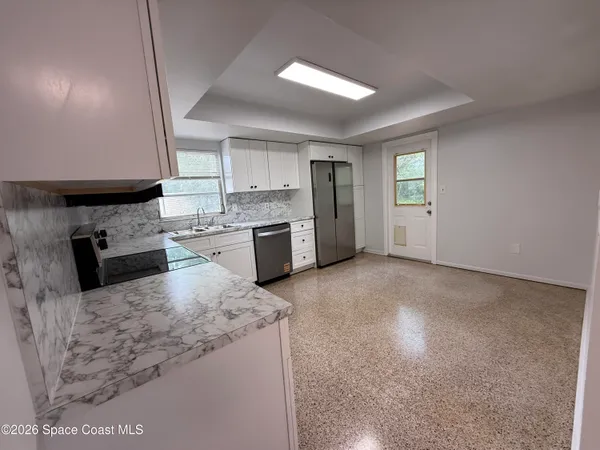 a kitchen with granite countertop stainless steel appliances and white cabinets