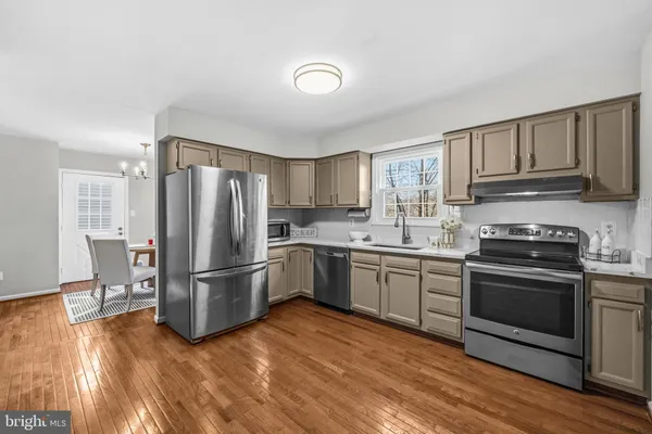 a kitchen with granite countertop a refrigerator stove top oven and sink