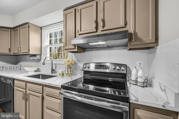 a kitchen with stainless steel appliances granite countertop a sink stove and cabinets