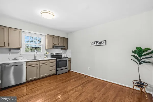 a kitchen with granite countertop a stove a sink and a refrigerator