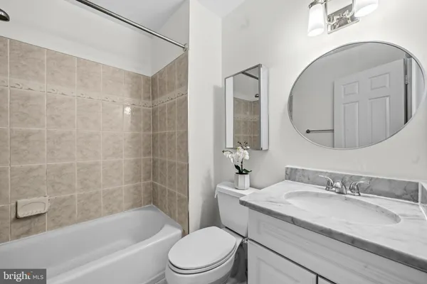 a bathroom with a granite countertop sink a toilet and bathtub