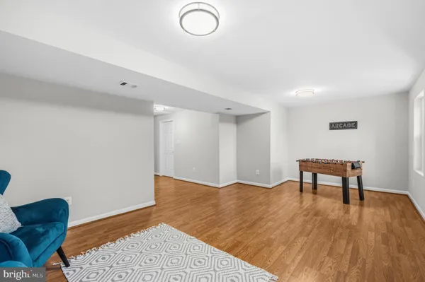 a view of an empty room with wooden floor and a chair