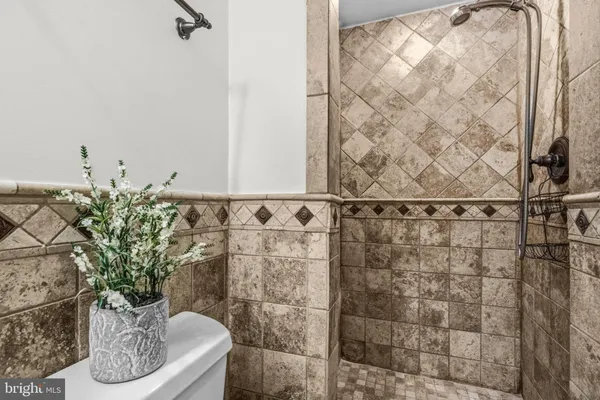 a bathroom with a potted plant and a shower
