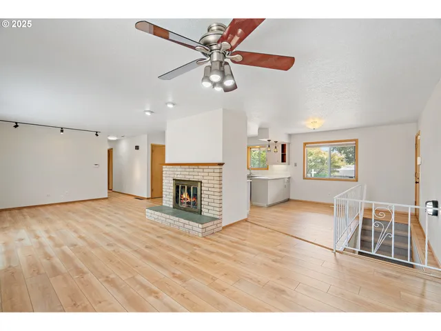 a view of an empty room with a fireplace and a window